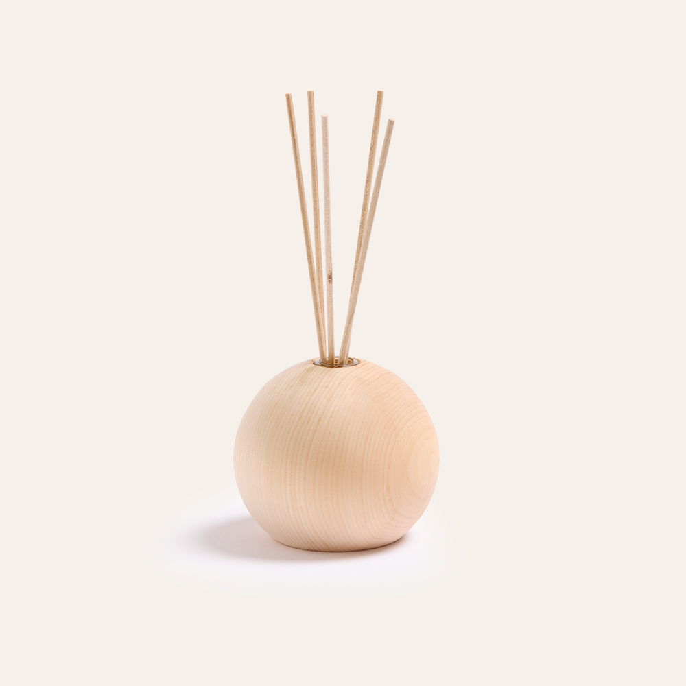 Zirbenholzdiffuser mit Duftstäbchen vor weißem Hintergrund