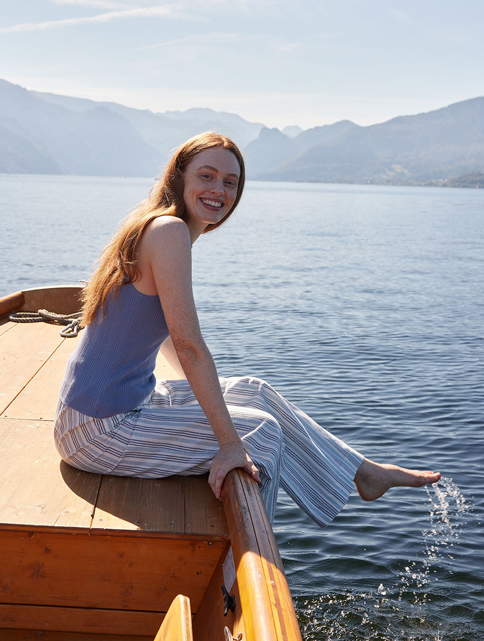 Lächelnde Frau sitzt im Boot am See