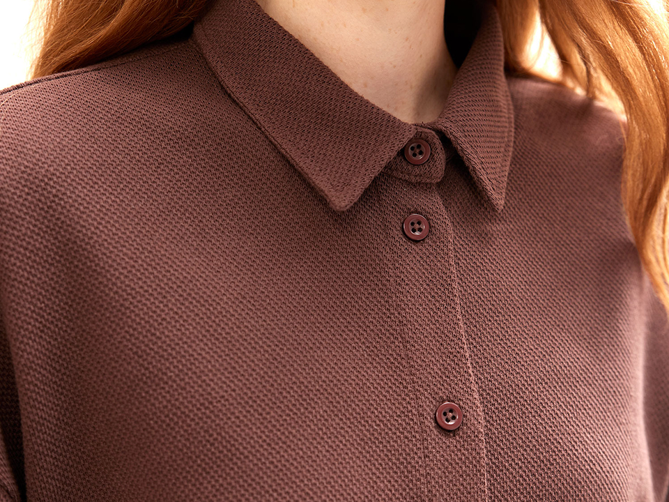Detailaufnahme von einem Shirt mit Kragen und Knöpfen