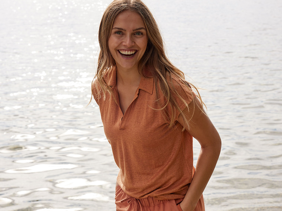 Frau trägt oranges Outfit und lächelt