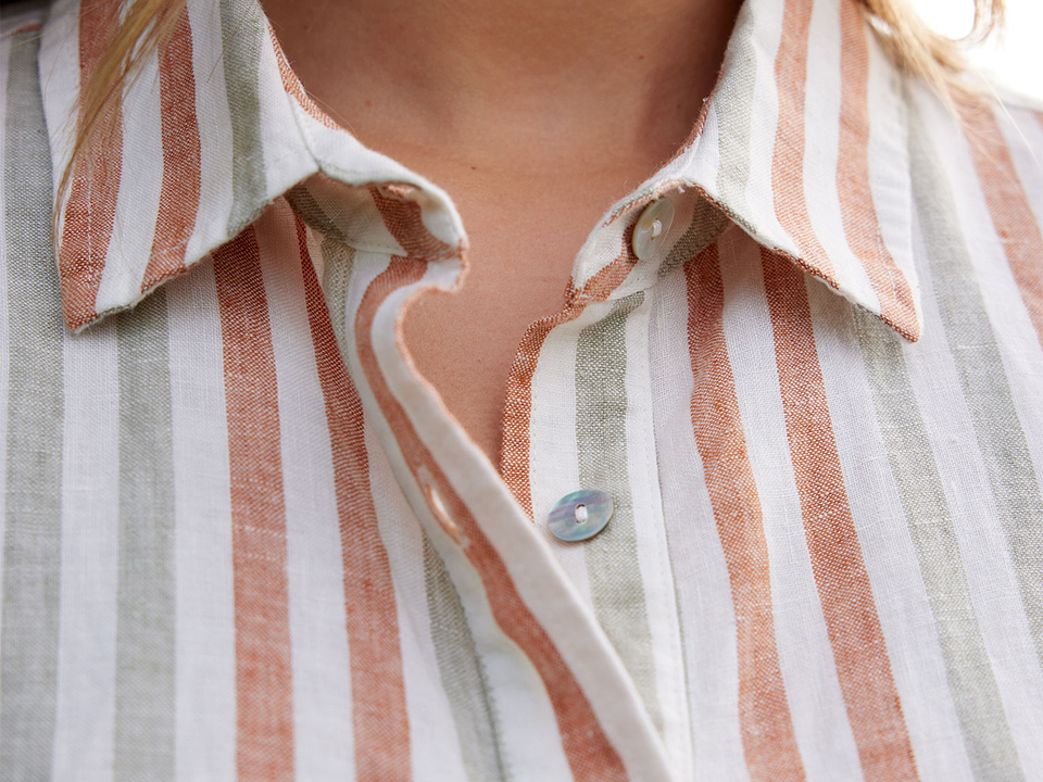 Detailaufnahme von einer gestreiften Bluse mit Knöpfen